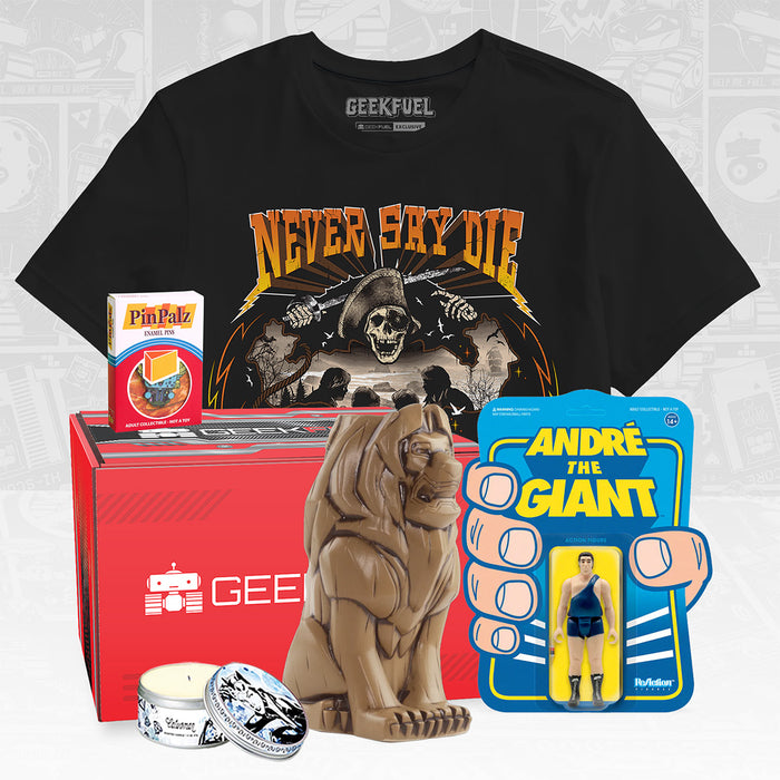 Depicted are the contents of a basic "Mystery Value Box": a Geek Fuel original t-shirt from sizes S-5XL, an amazing tiki mug from Mondo, a Super7 ReAction figure (in this case, Andre the Giant), and Pin Palz enamel pin, and a Catwoman scented candle.